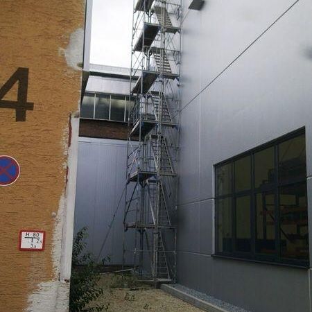 Gebäude, umgeben von einem Gerüst, mit einer Leiter
