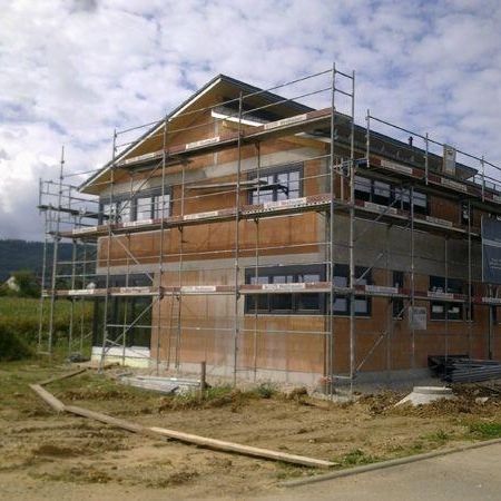 Ein Haus, das sich im Bau befindet, umgeben von einem stabilen Gerüst