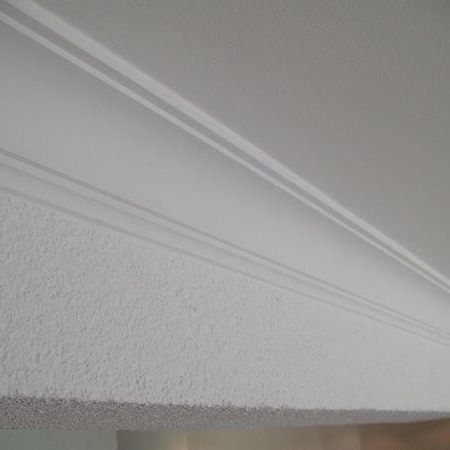 Weißer Deckenbereich mit weißer Stuckleiste