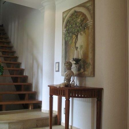 Ein Holztisch mit einem Gemälde darauf, umgeben von kunstvollen Stuckarbeiten