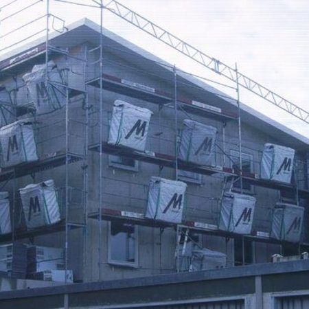 Haus mit Gerüst, wo gerade die Wärmedämmung angebracht wird