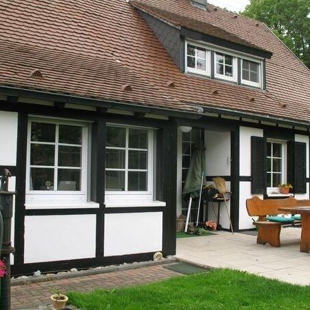 Ansicht von einem Haus mit einem Tisch und Stühlen im Garten